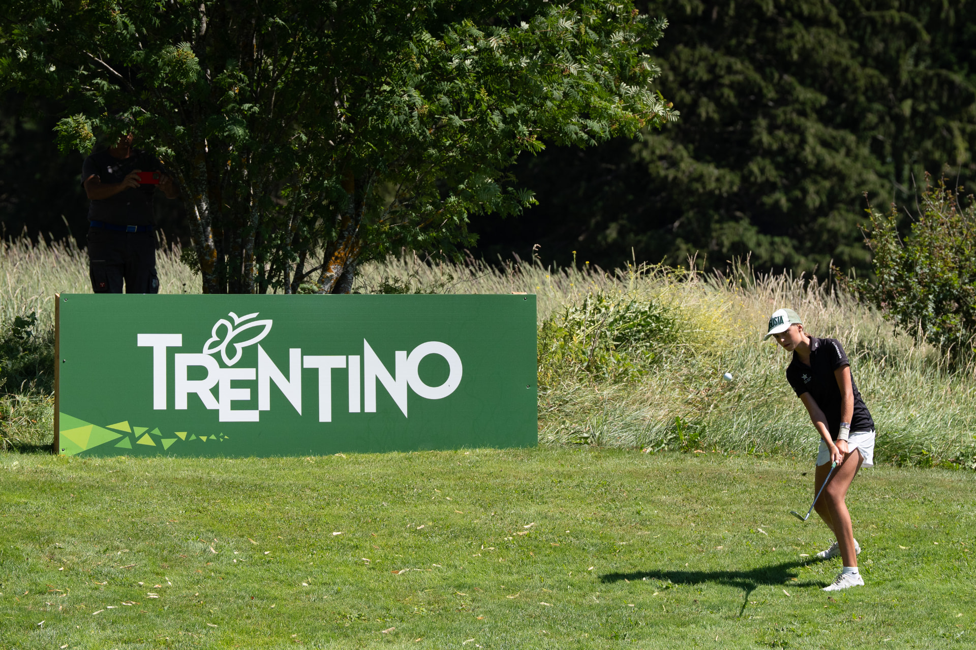 Atleta in gara accanto al pannello Trentino